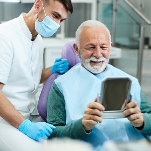Patient looking at reflection in mirror with dentist