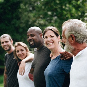 New Baltimore dental implants patient smiling with friends
