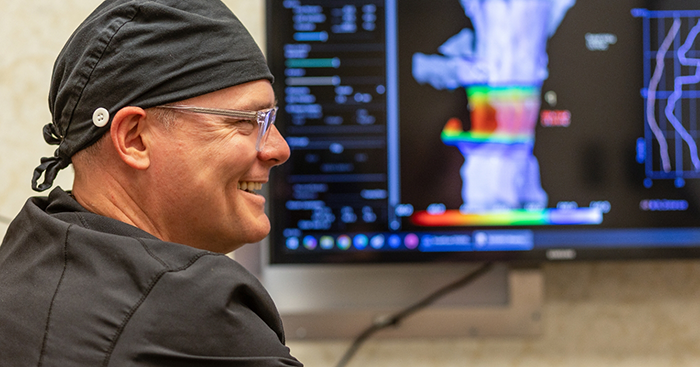 Man in dental chair smiling up at his dentist in New Baltimore