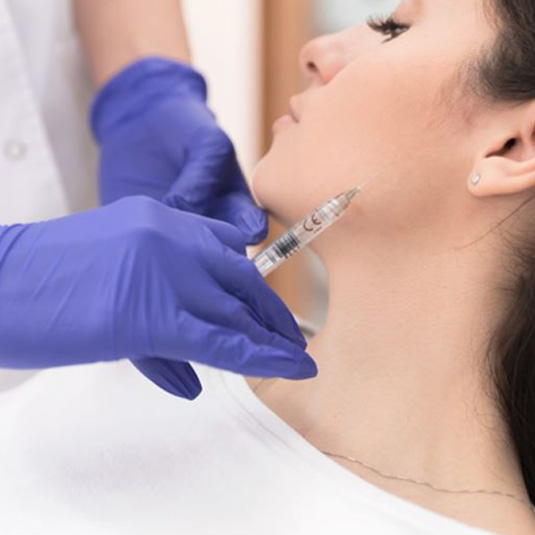 Woman receiving BOTOX injection near her jaw