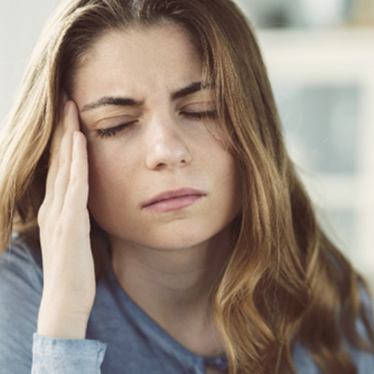 Woman suffering from TMD-related headache