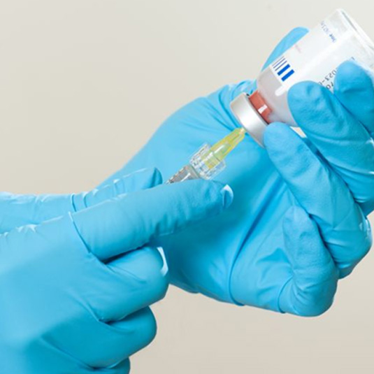 Gloved hands preparing BOTOX injection