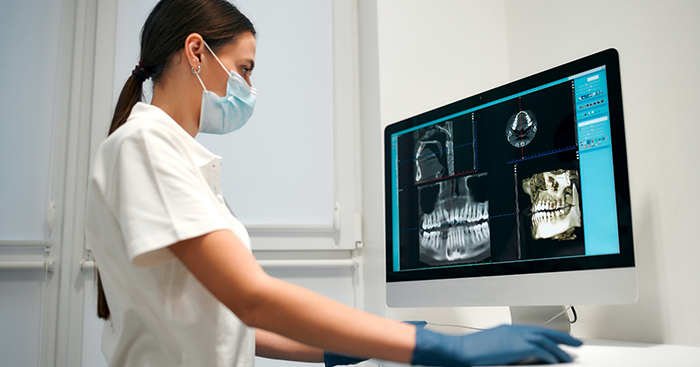 Dentist looking at a computer with digital models of a patients teeth and jaws