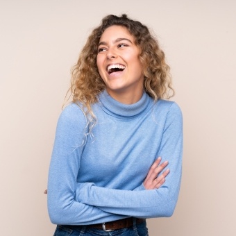 woman in blue smiling after headache relief