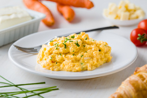 Plate of scrambled eggs with a fork